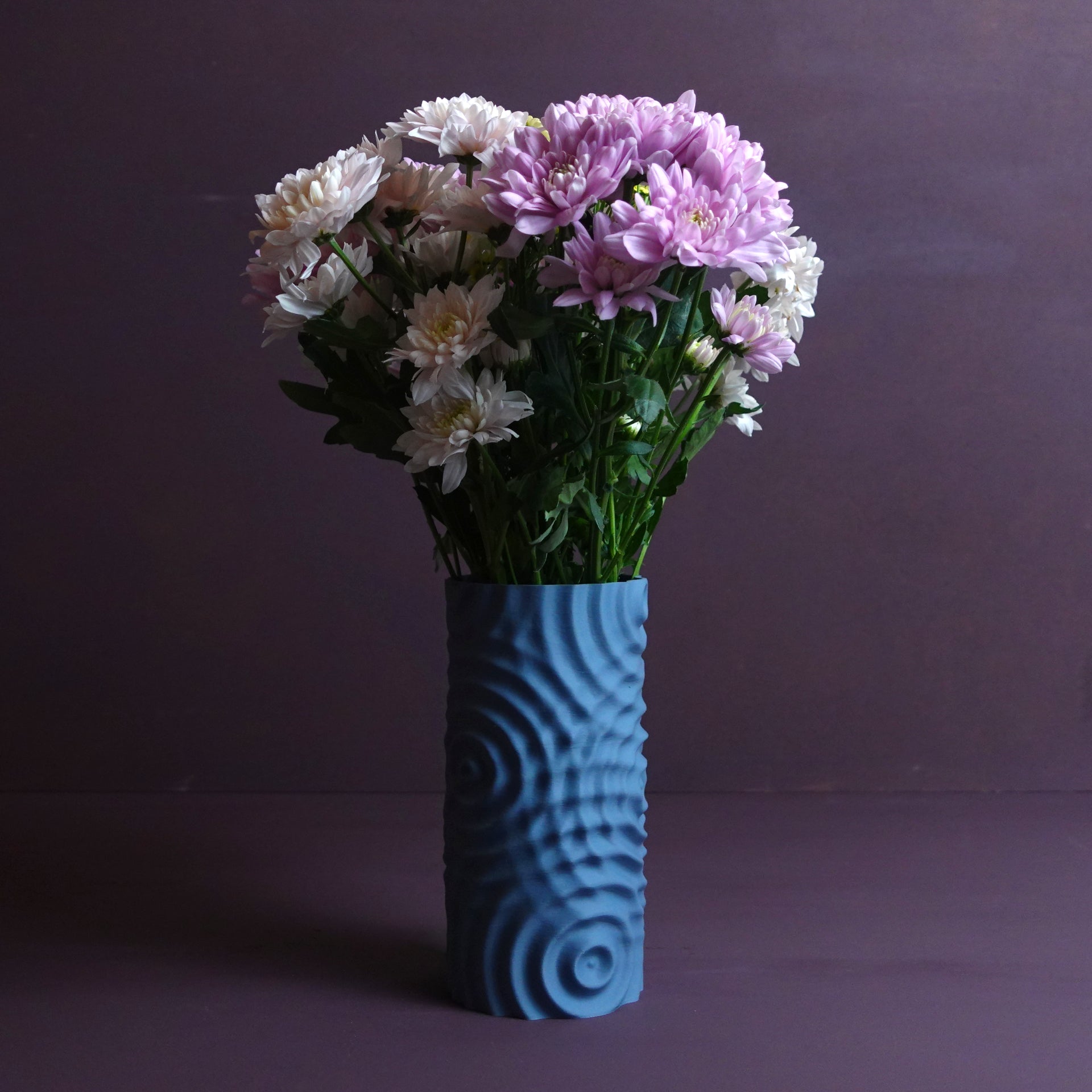 a blue vase filled with purple and white flowers
