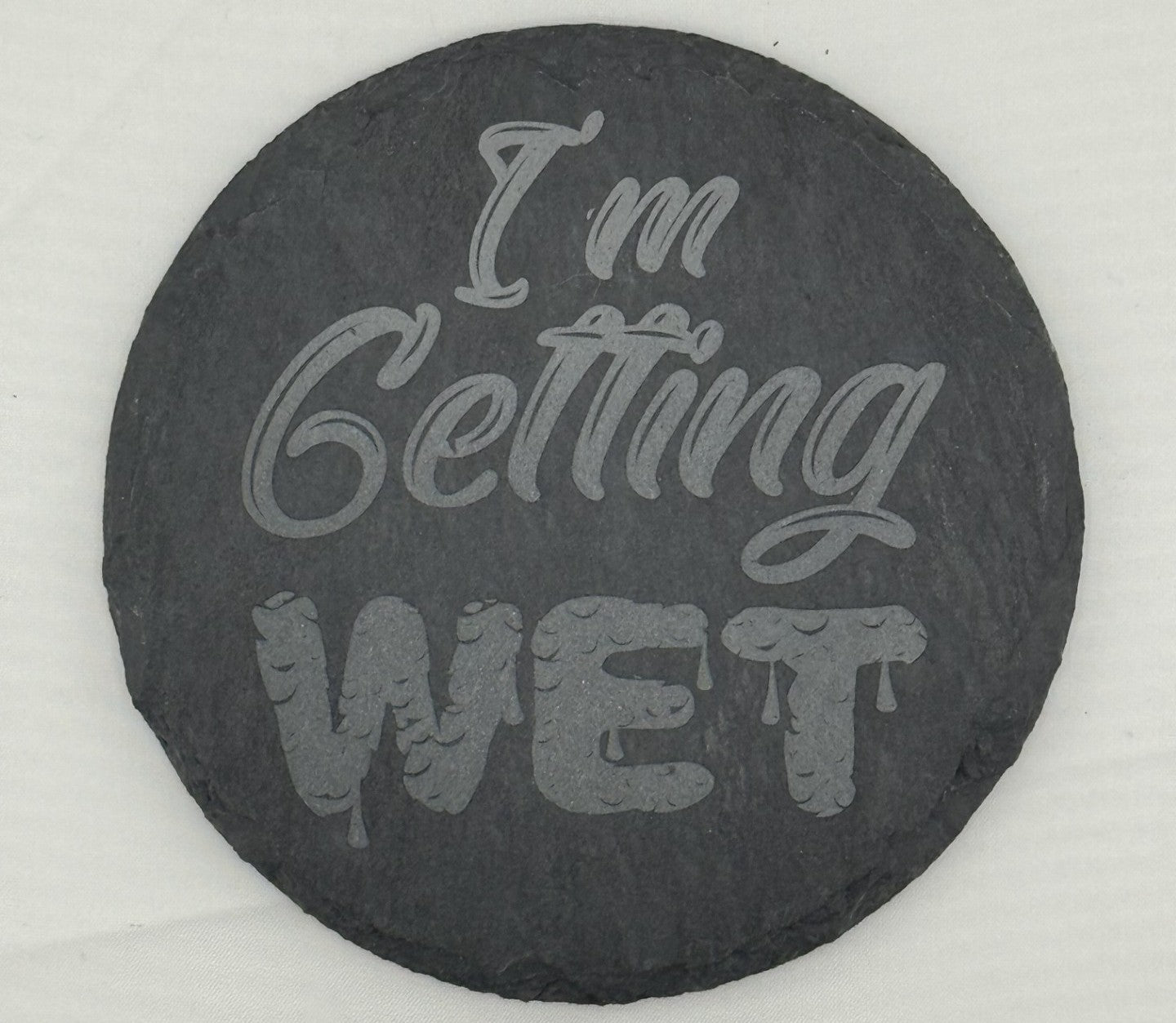 a black stone with the words i'm getting wet written on it