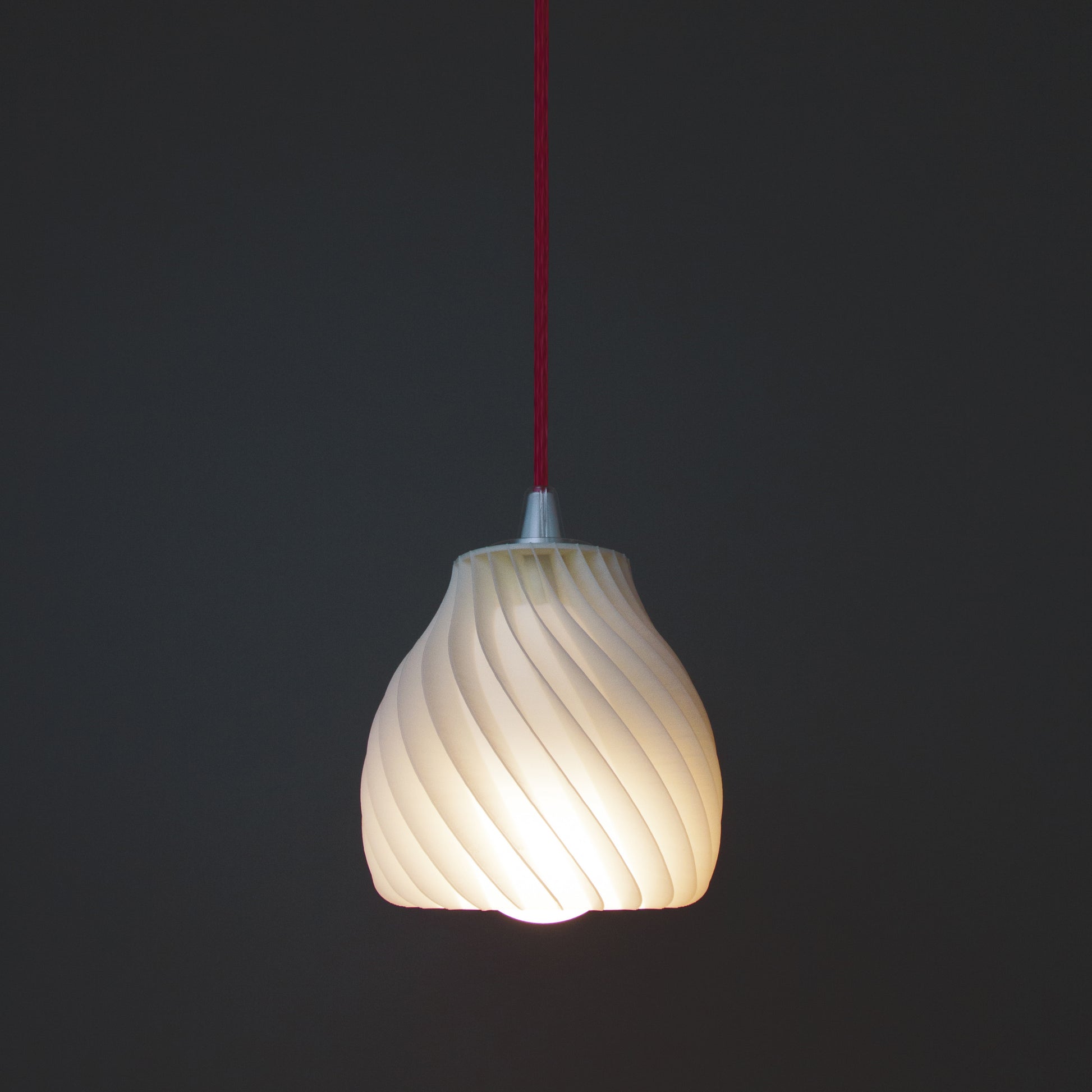 a white light bulb hanging from a red cord