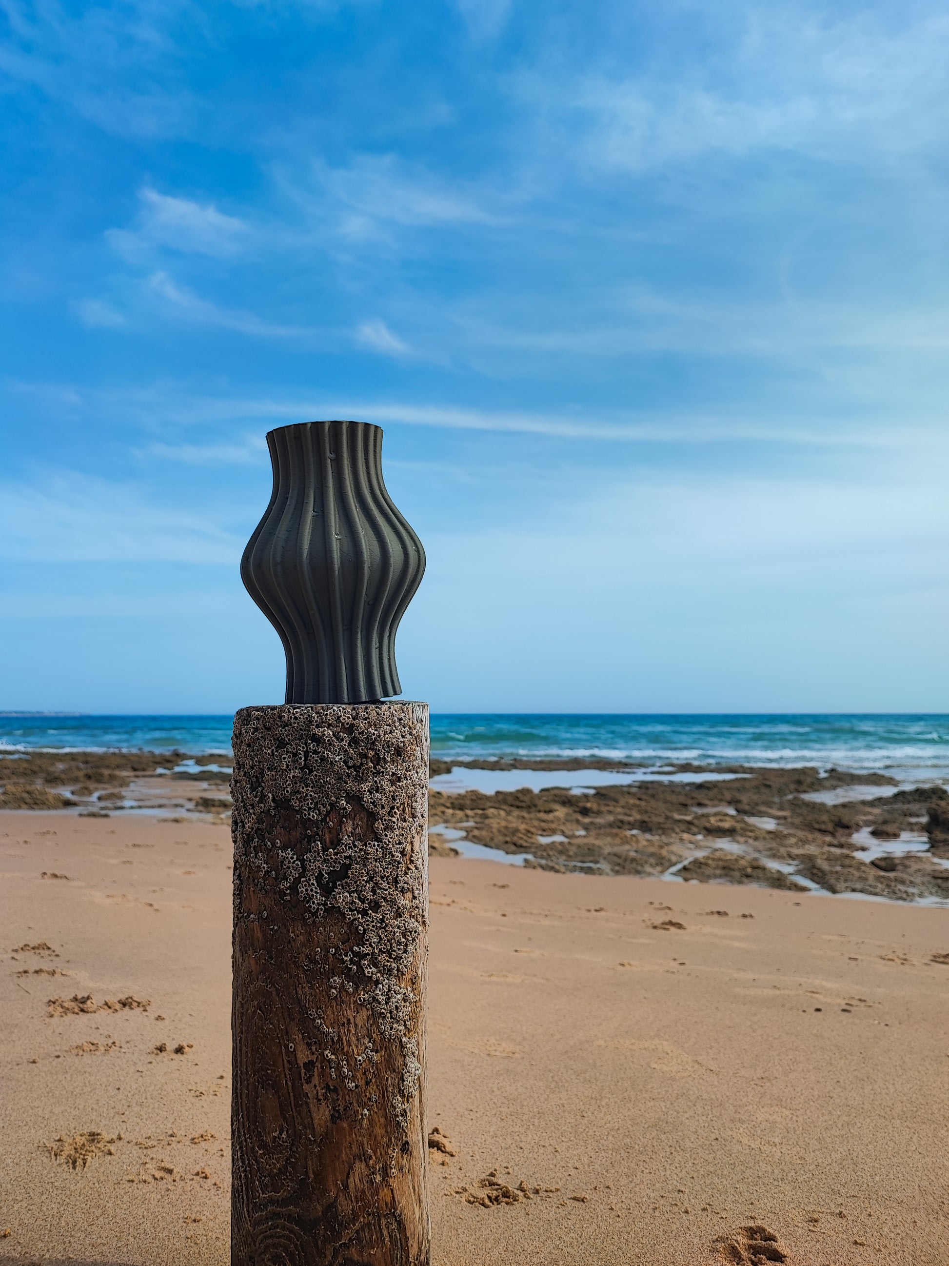 a sculpture on a beach near the ocean