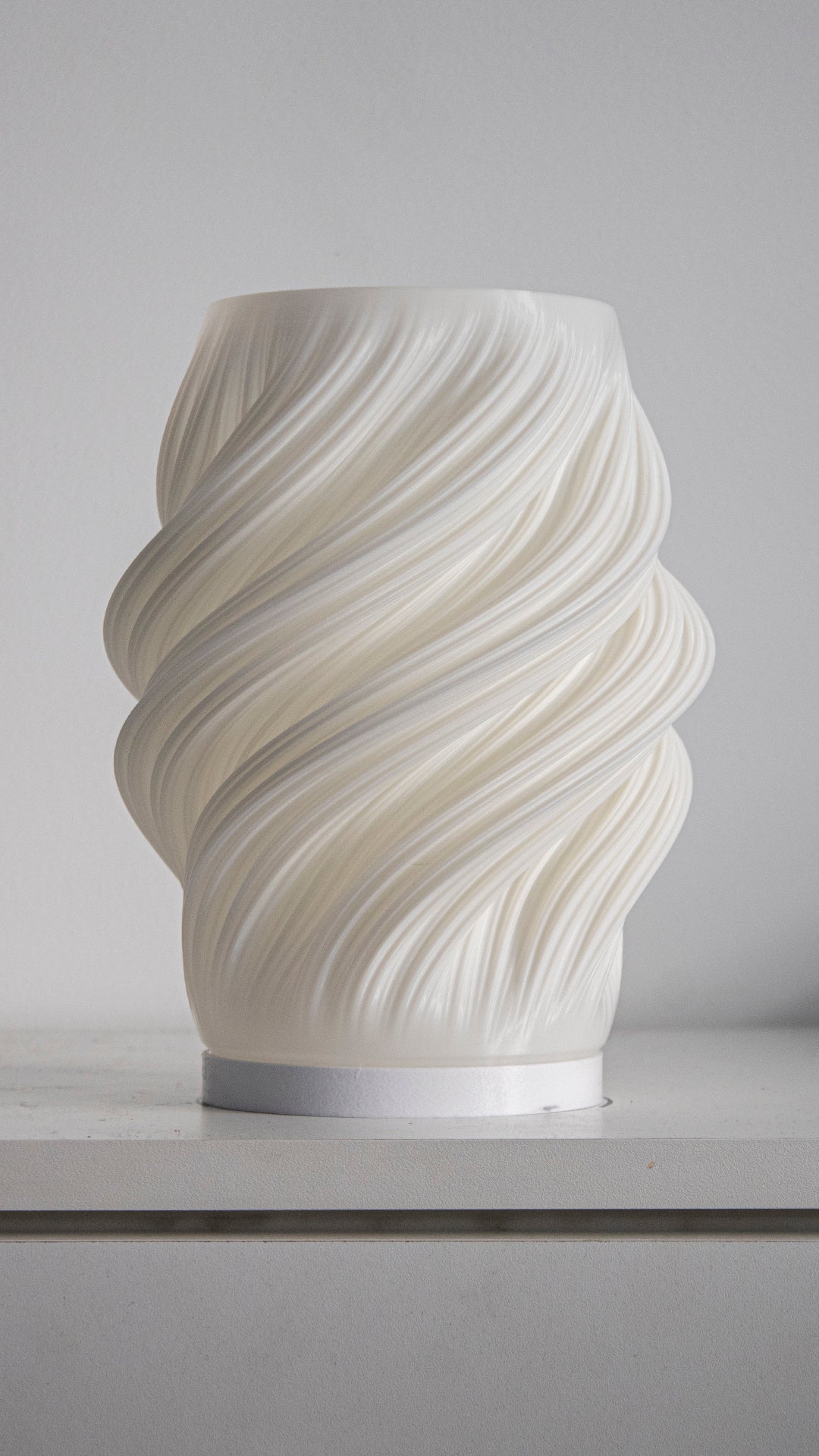 a white vase sitting on top of a counter