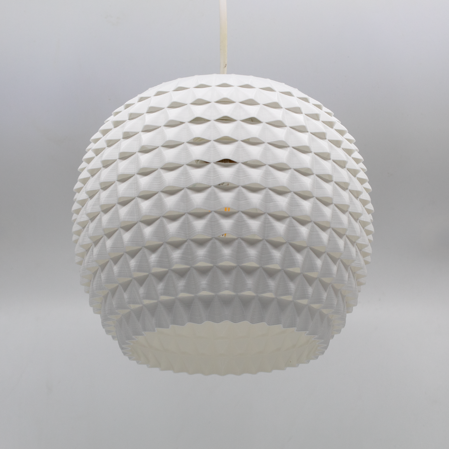 a white light fixture hanging from a ceiling