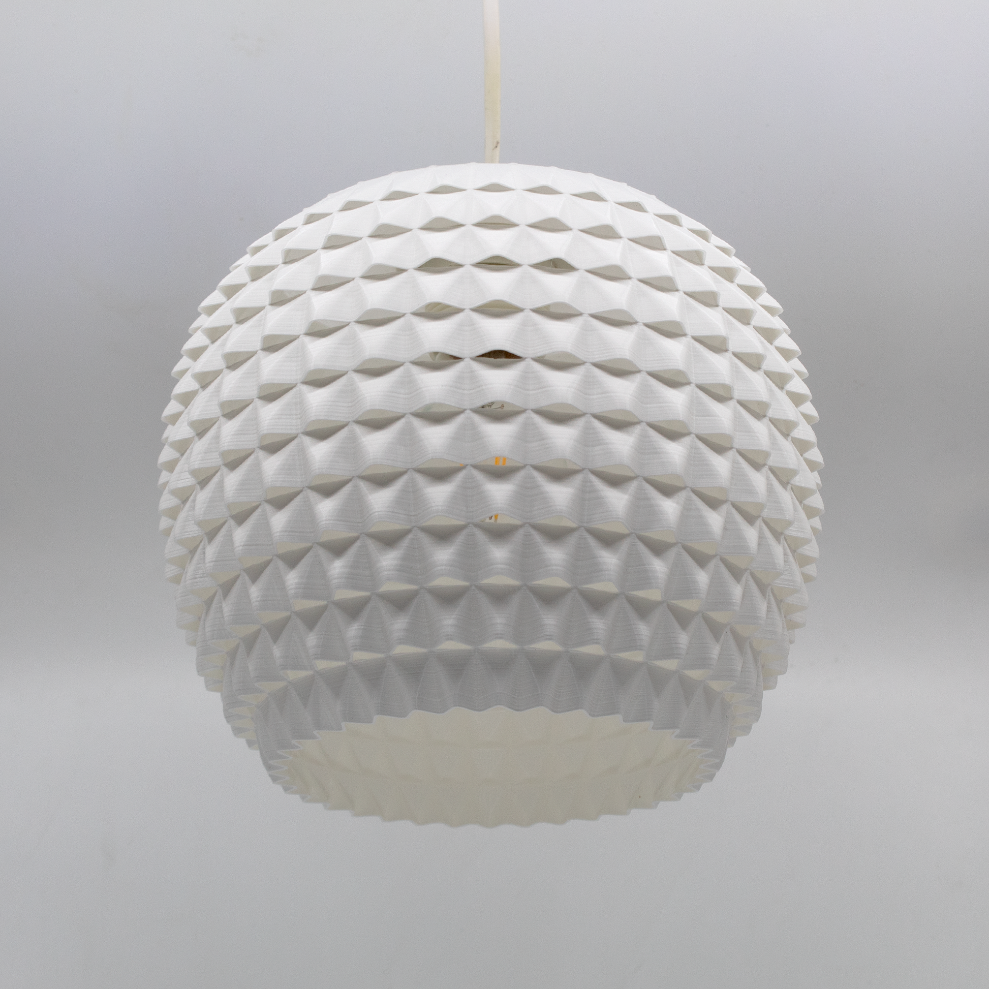 a white light fixture hanging from a ceiling
