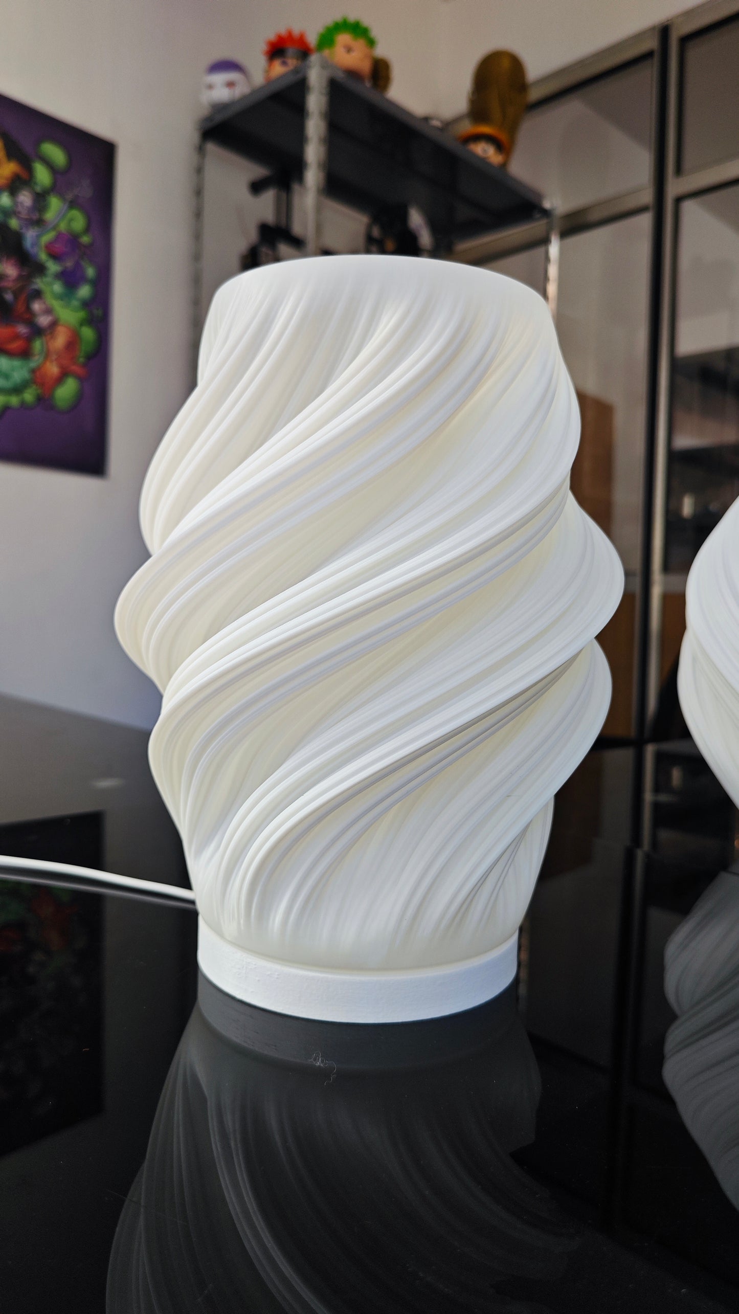 a white vase sitting on top of a black table