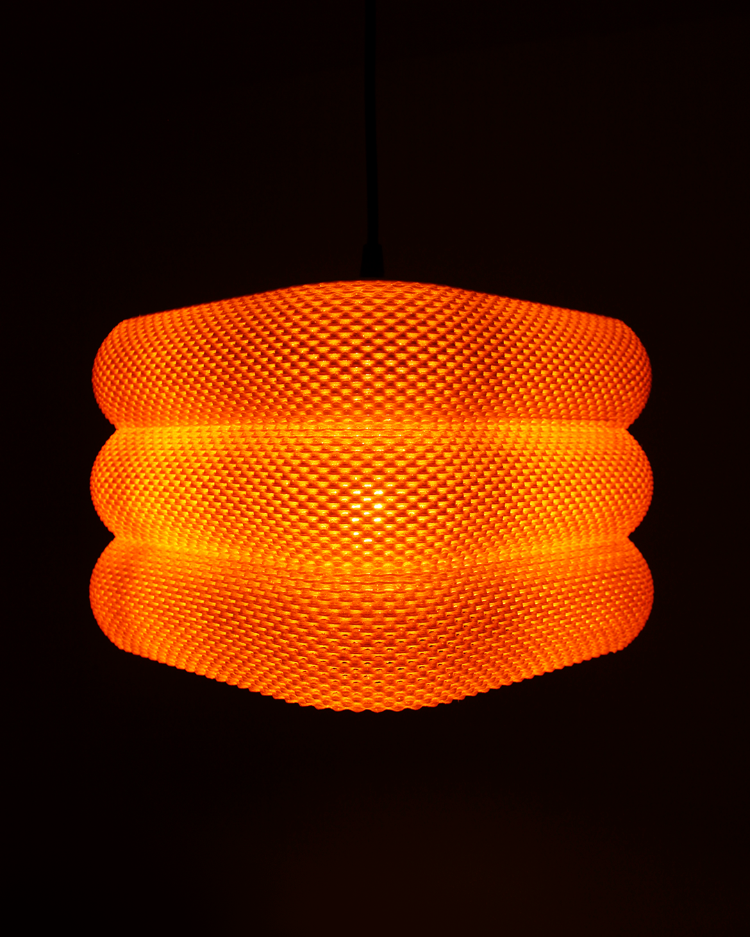 a large orange light hanging from a ceiling