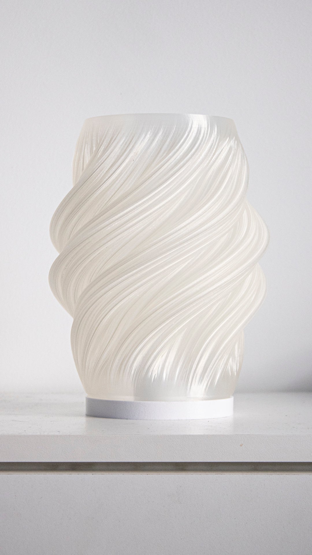 a white vase sitting on top of a counter