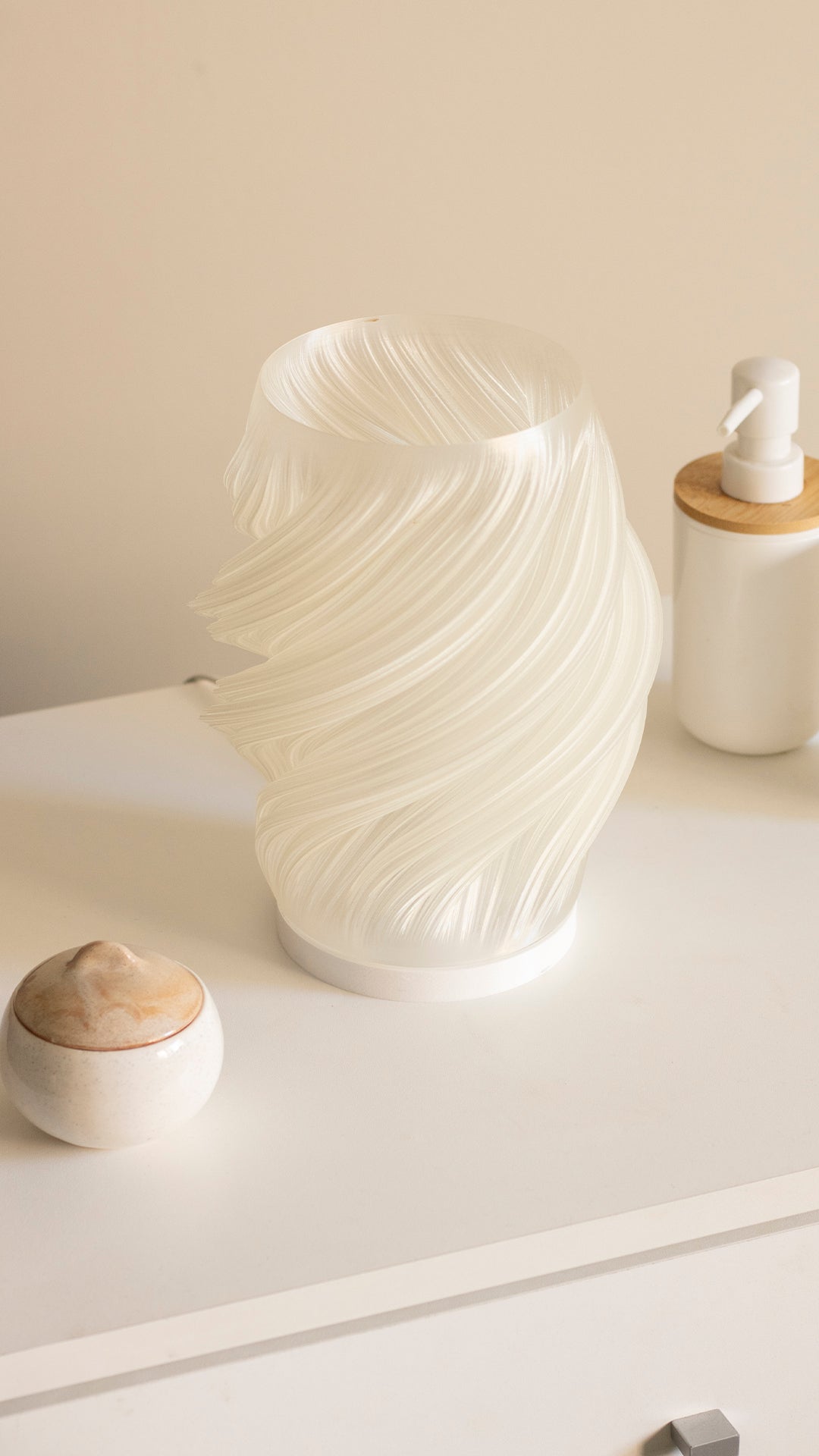 a white vase sitting on top of a white dresser