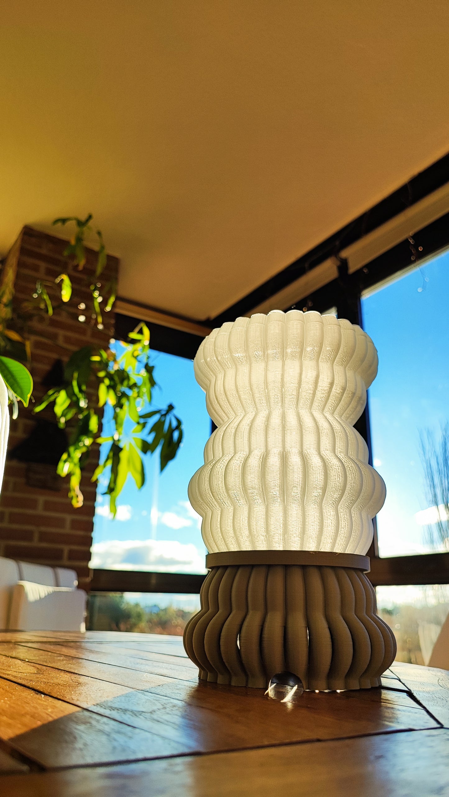 a white vase sitting on top of a wooden table