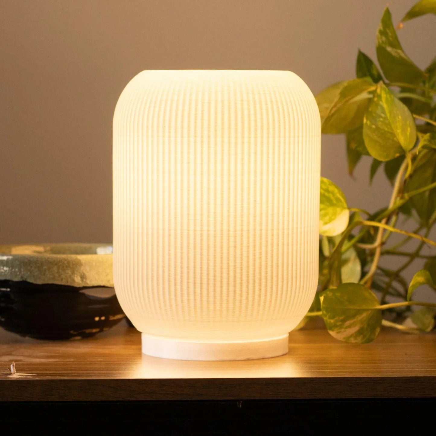 a white lamp sitting on top of a wooden table
