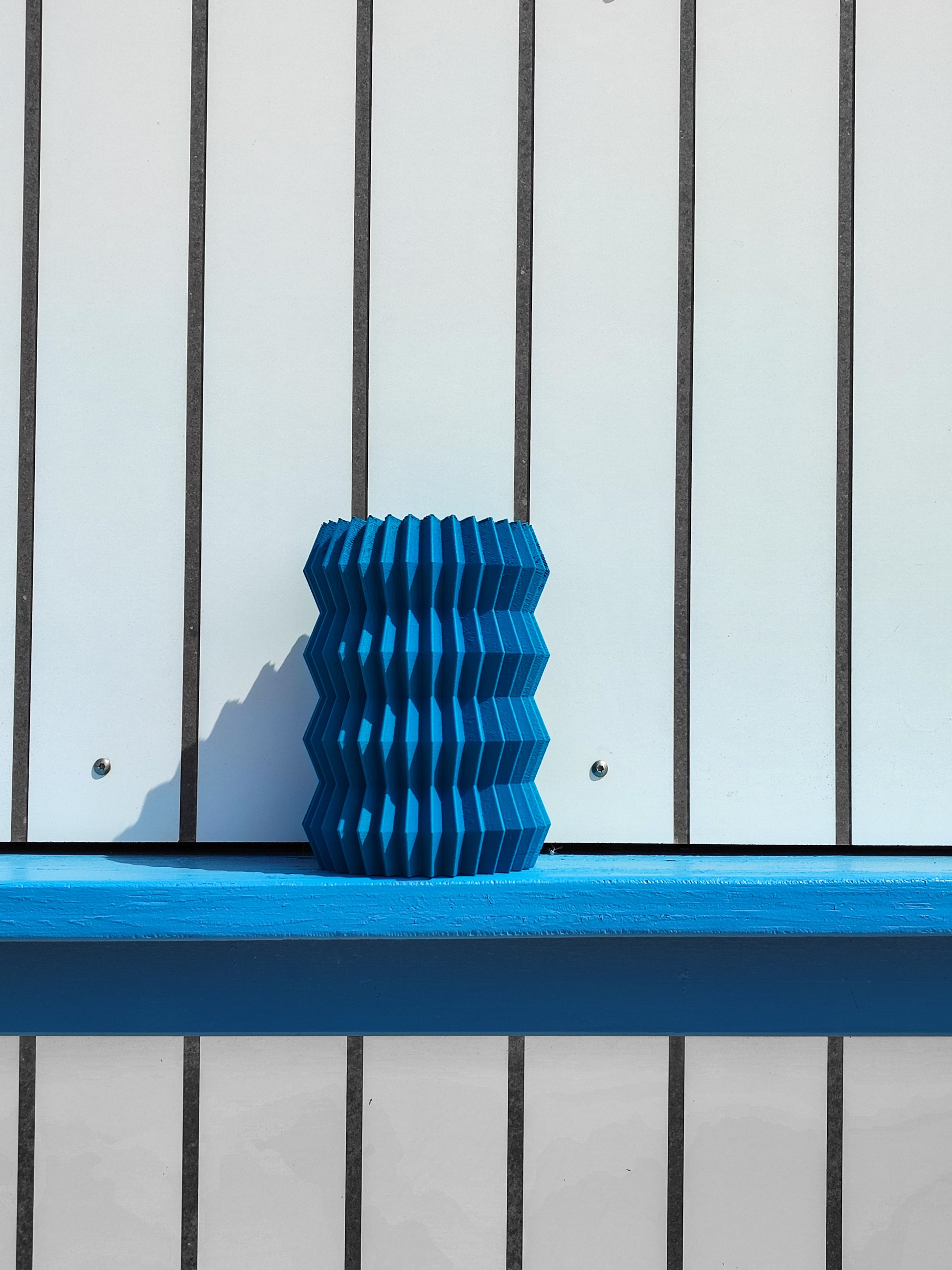 a blue vase sitting on top of a blue bench