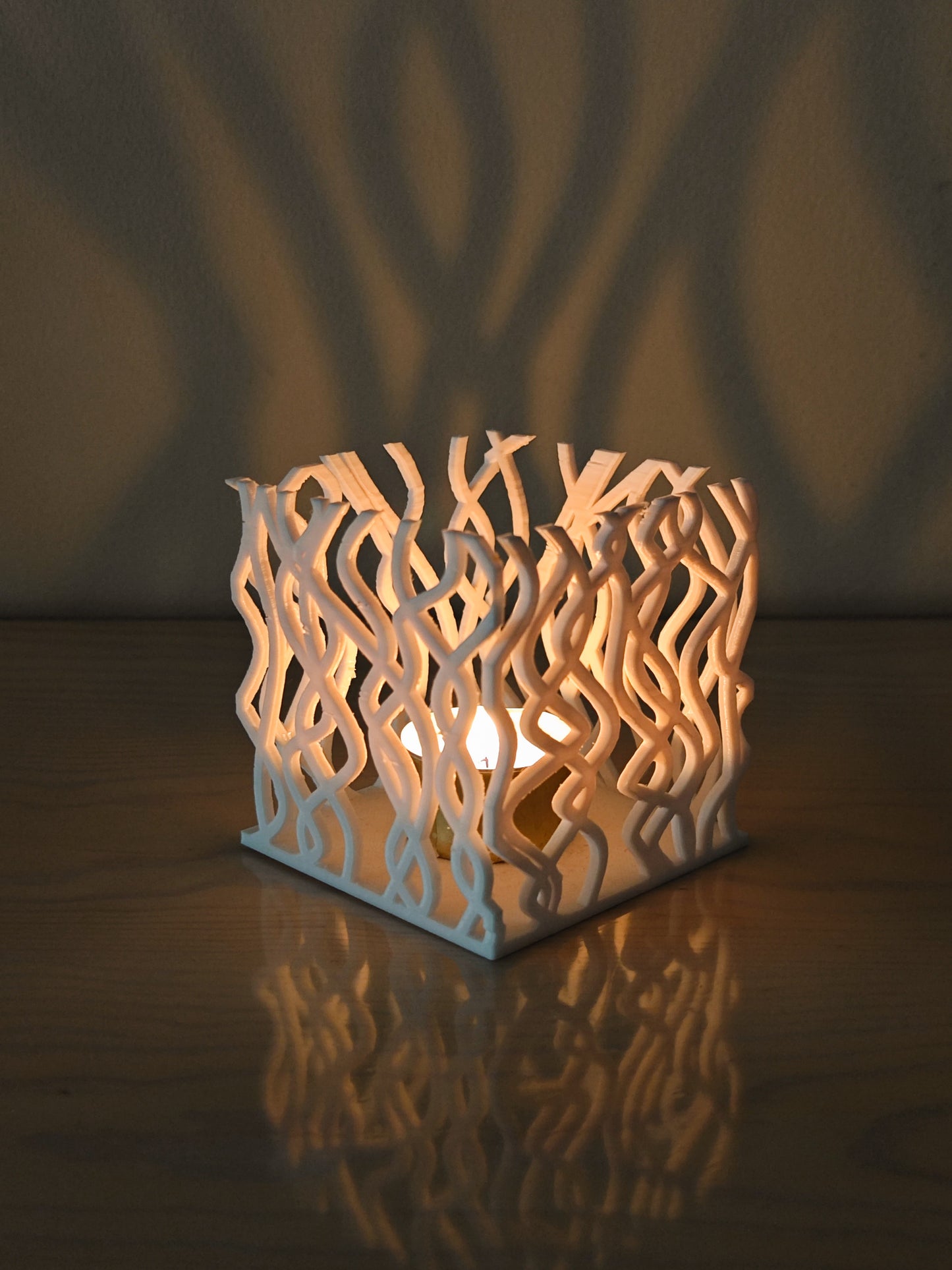 a white candle holder sitting on top of a wooden table