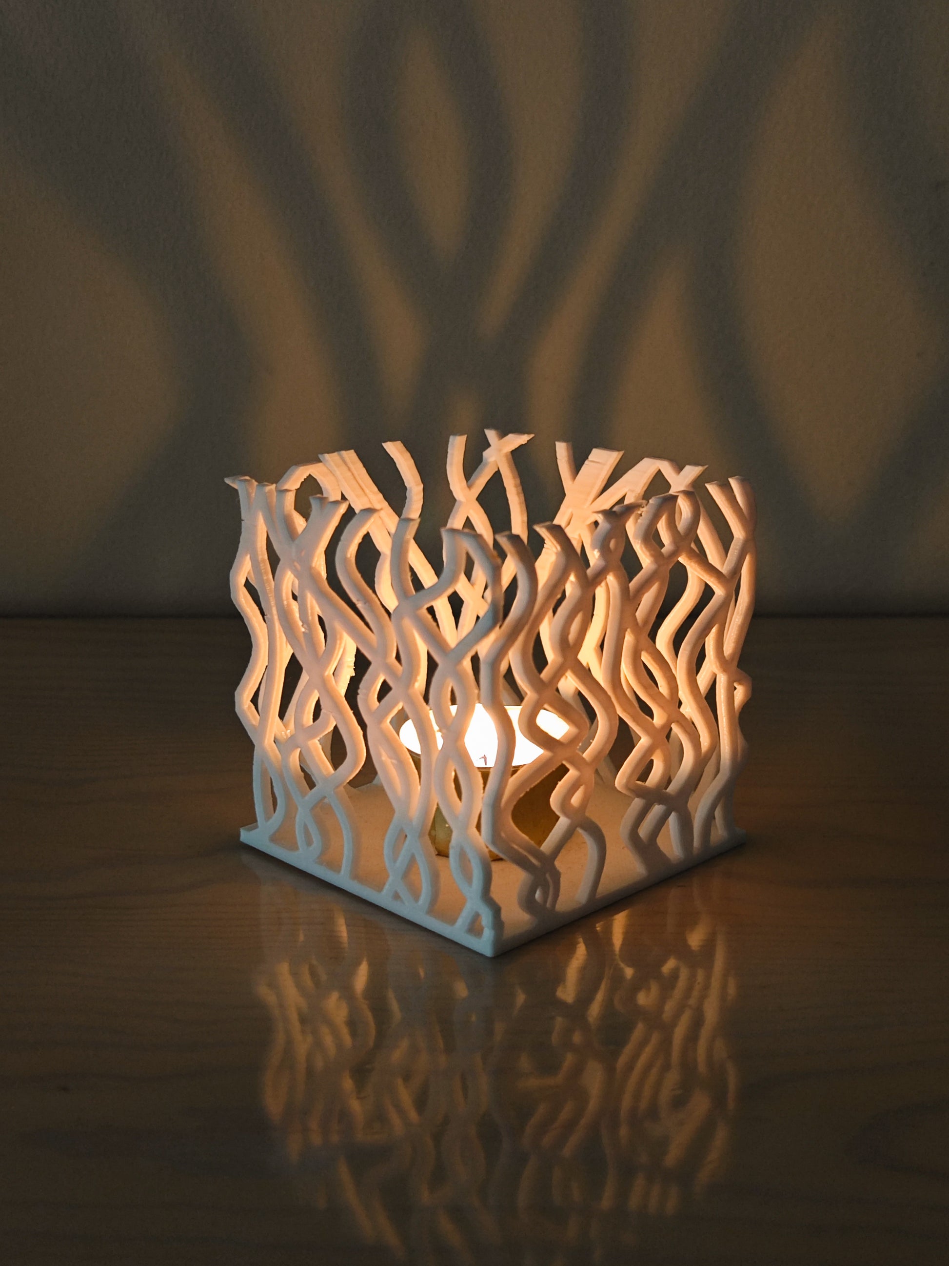 a white candle holder sitting on top of a wooden table