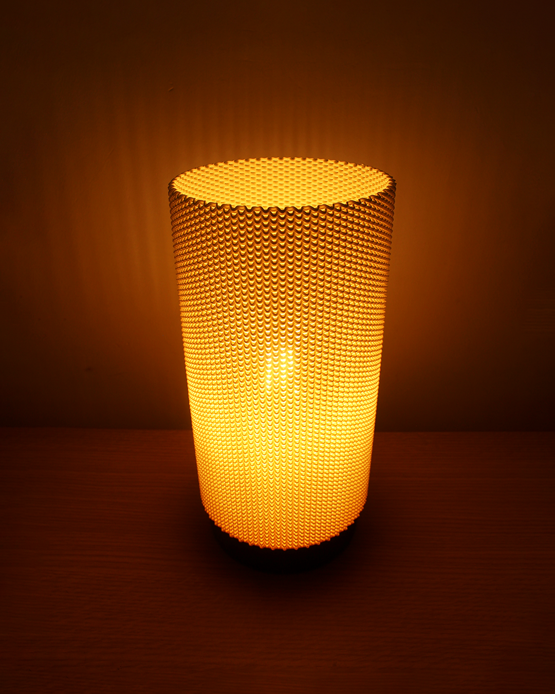 a lit up vase sitting on top of a table