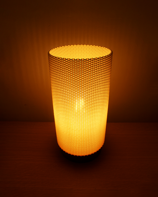 a lit up vase sitting on top of a table