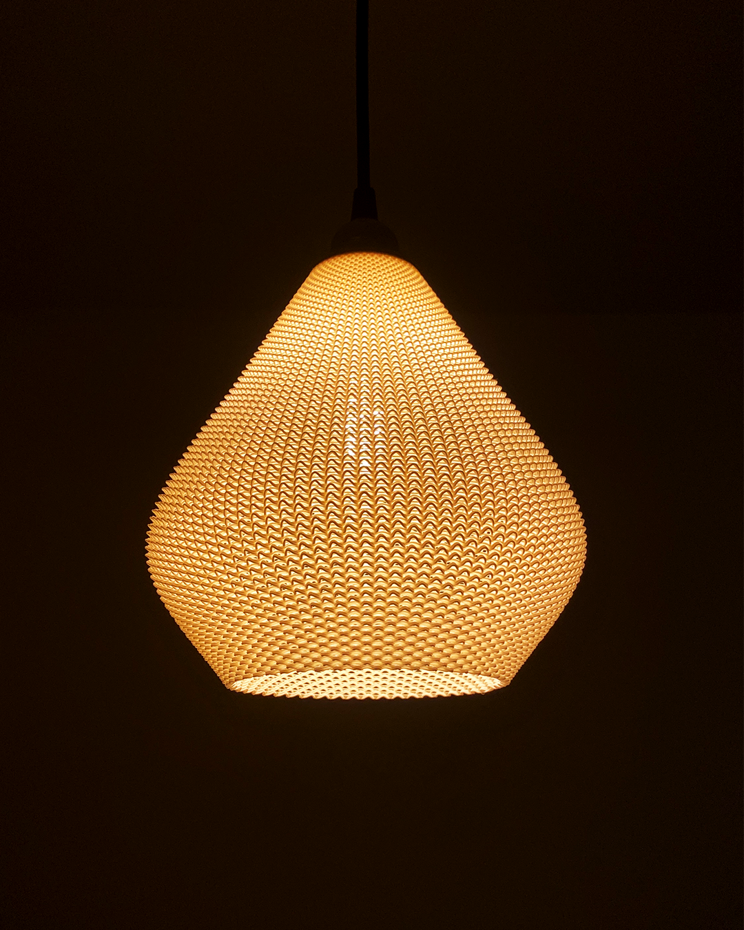 a light hanging from a ceiling in a dark room