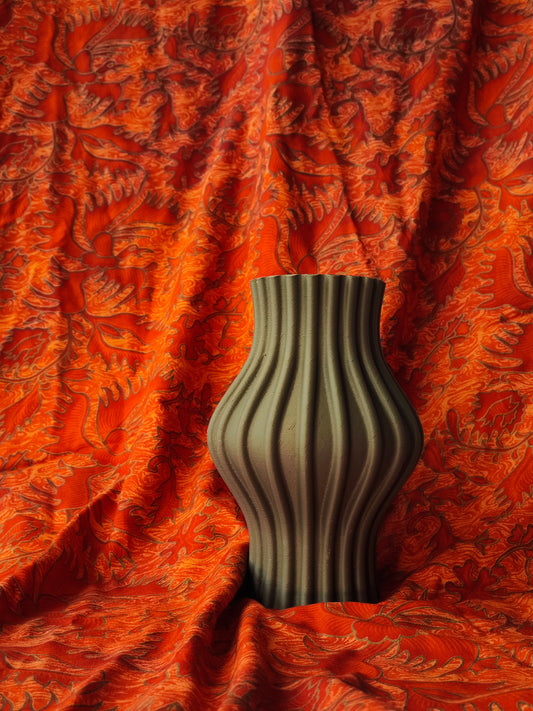 a striped vase sitting on a red cloth