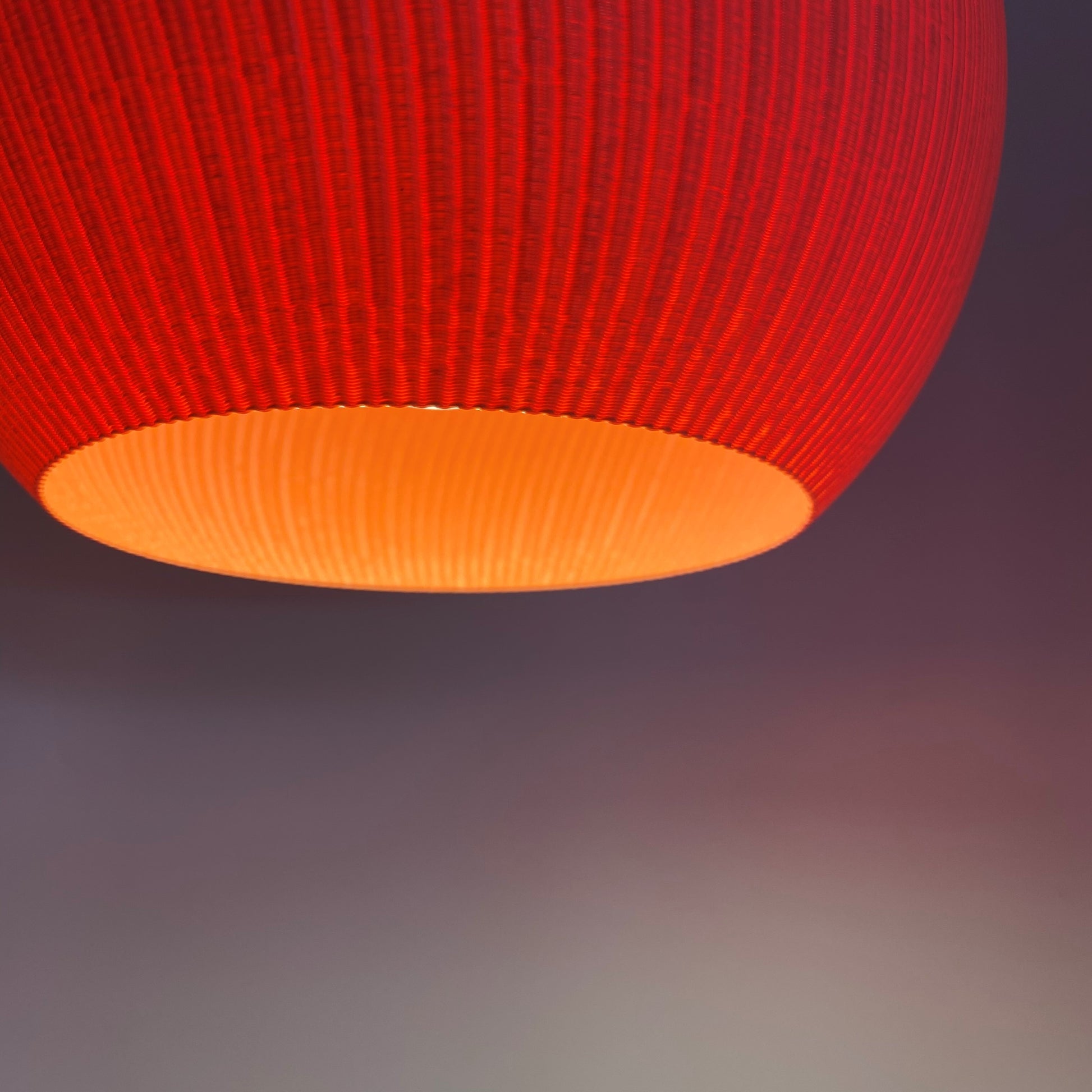 a red lamp hanging from a ceiling in a room