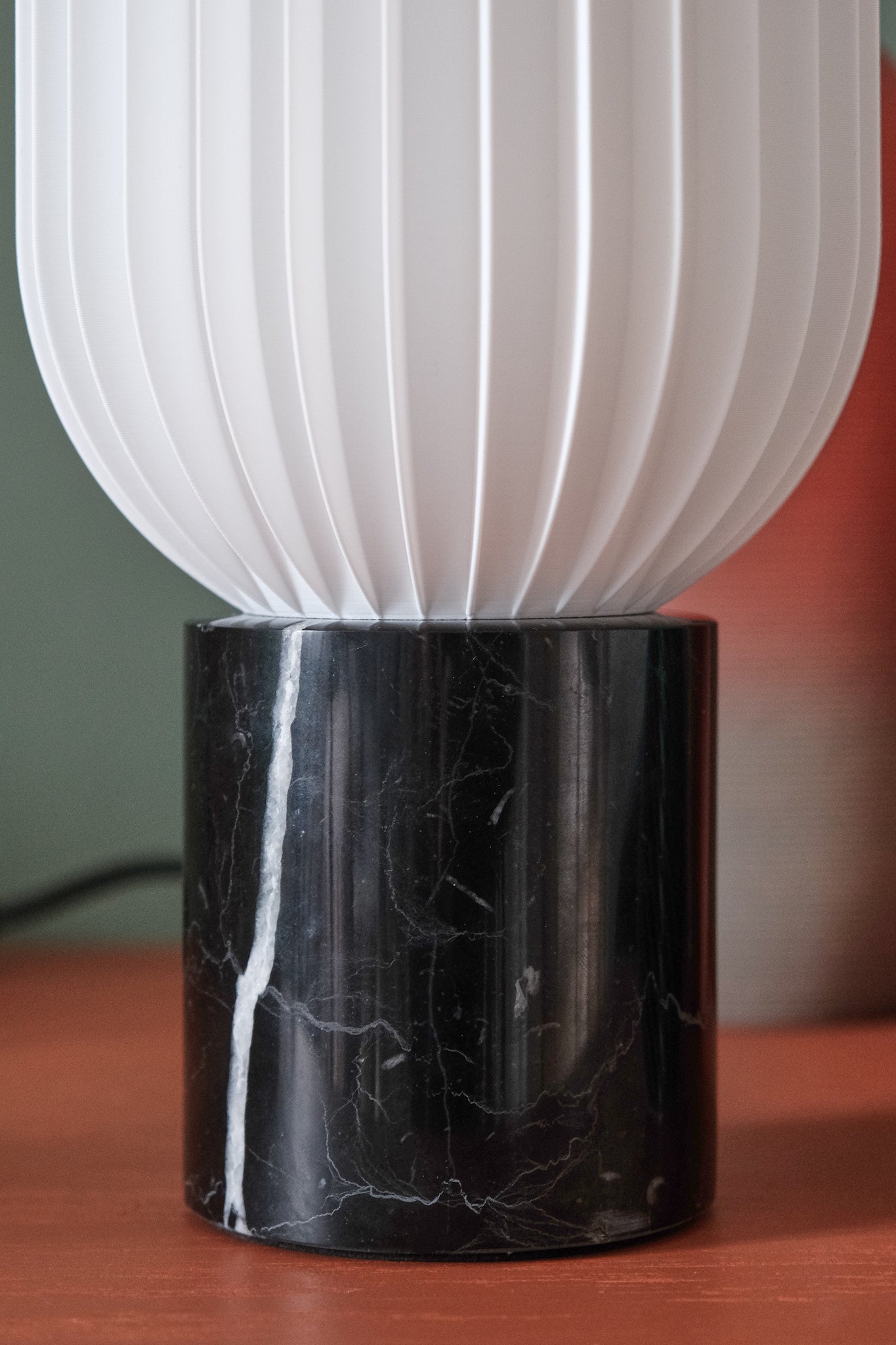a black and white lamp sitting on top of a wooden table