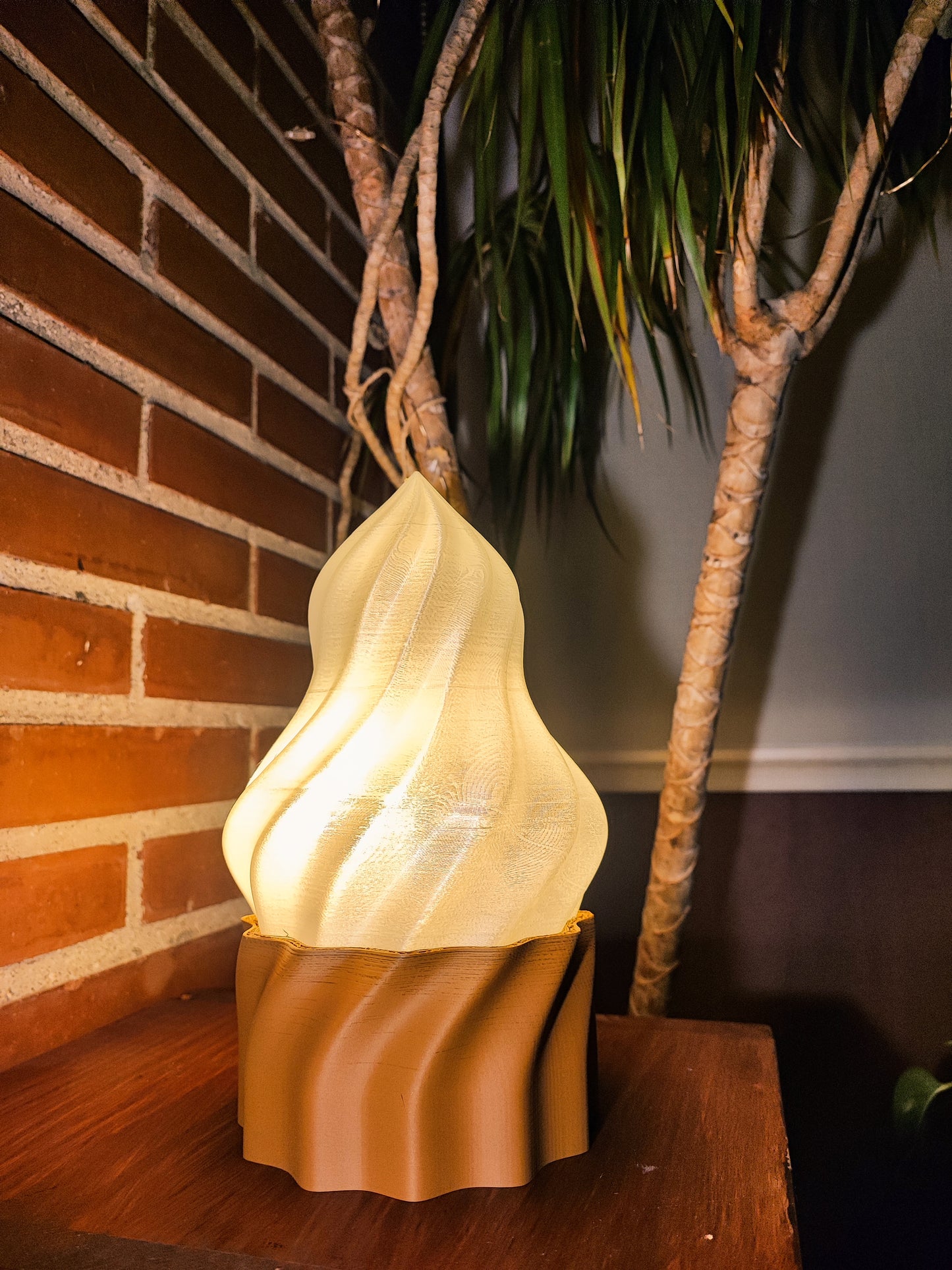 a lamp sitting on top of a wooden table next to a palm tree