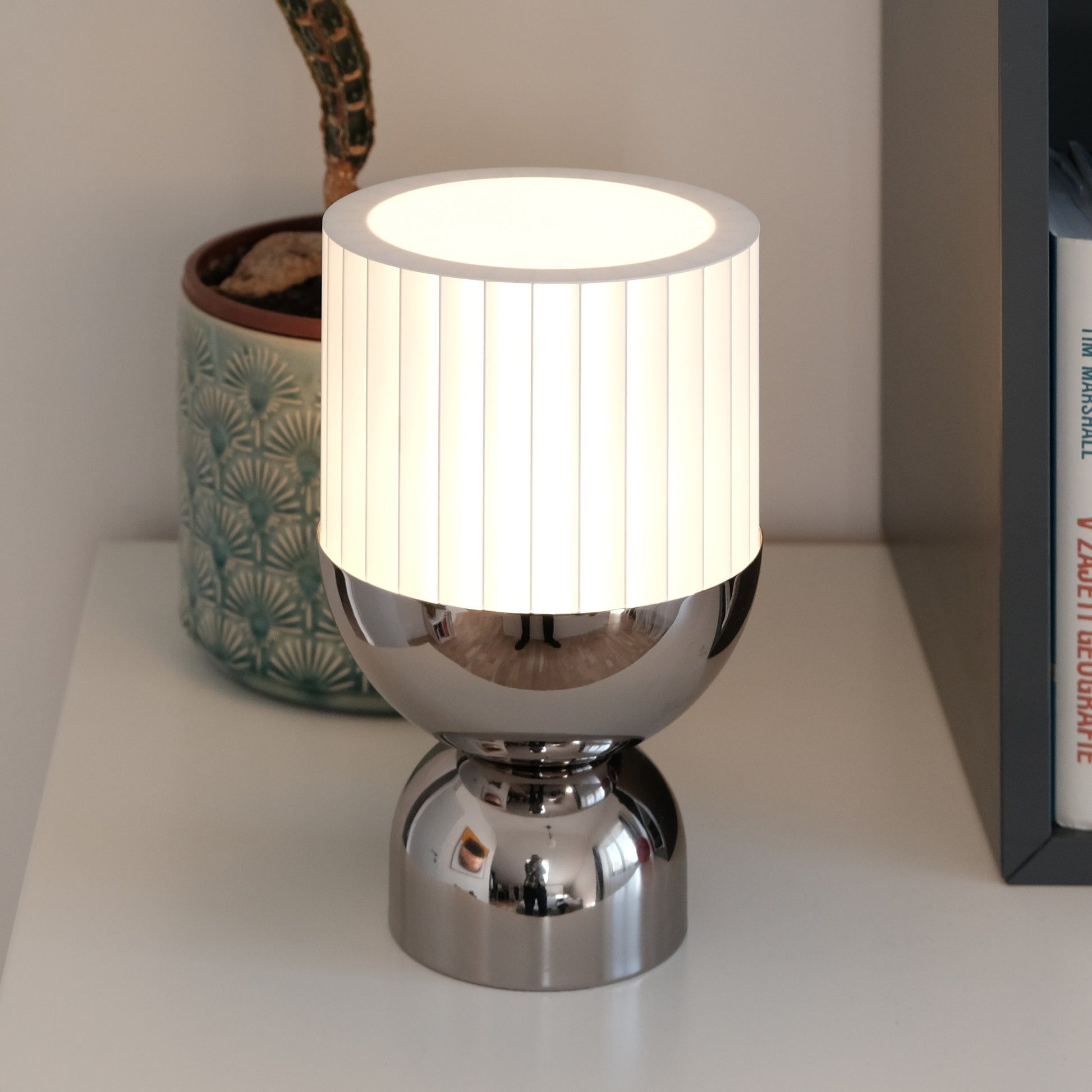 a lamp sitting on top of a table next to a book