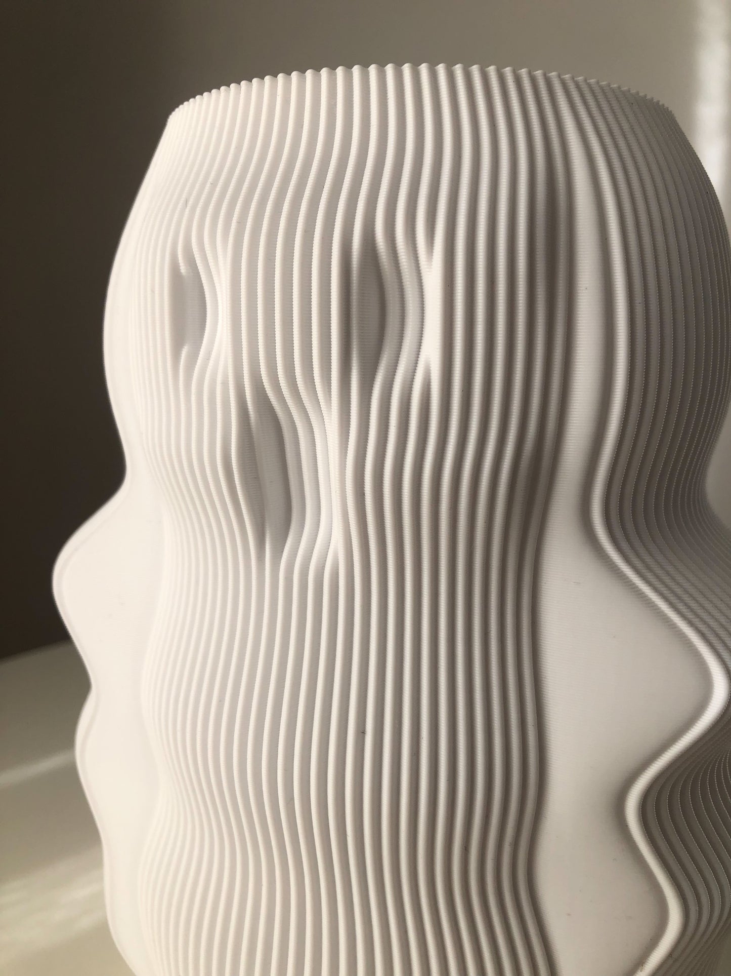 a white vase sitting on top of a table