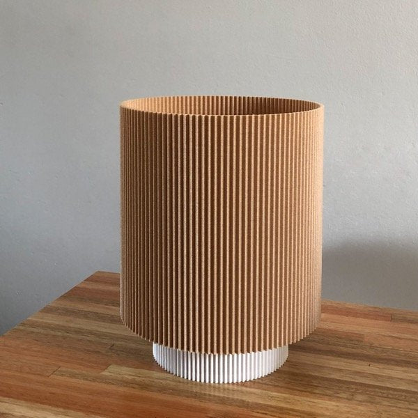 a brown and white vase sitting on top of a wooden table