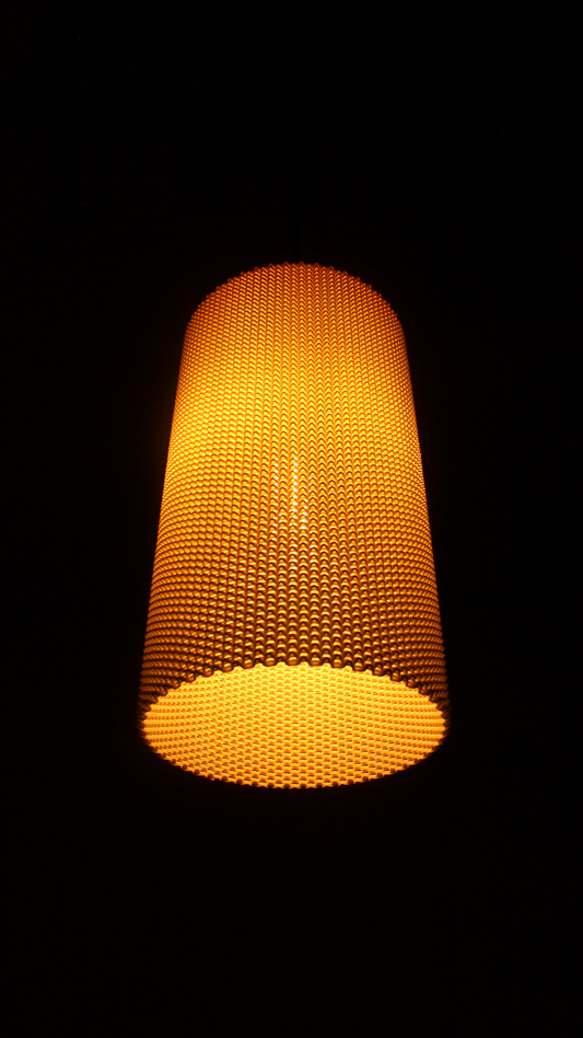 a yellow lamp hanging from a ceiling in a dark room