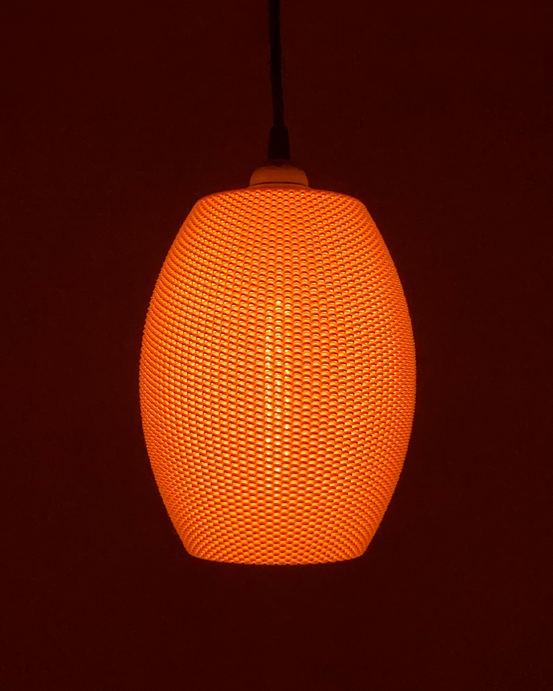 a large orange light hanging from a ceiling