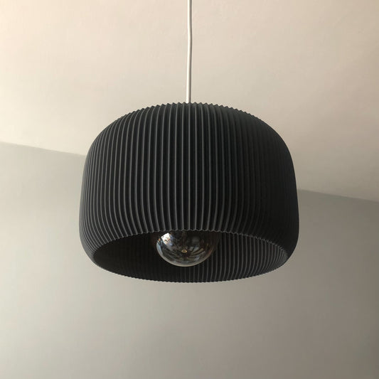 a black lamp hanging from a ceiling in a room