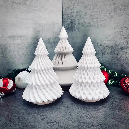 three paper christmas trees sitting on top of a table
