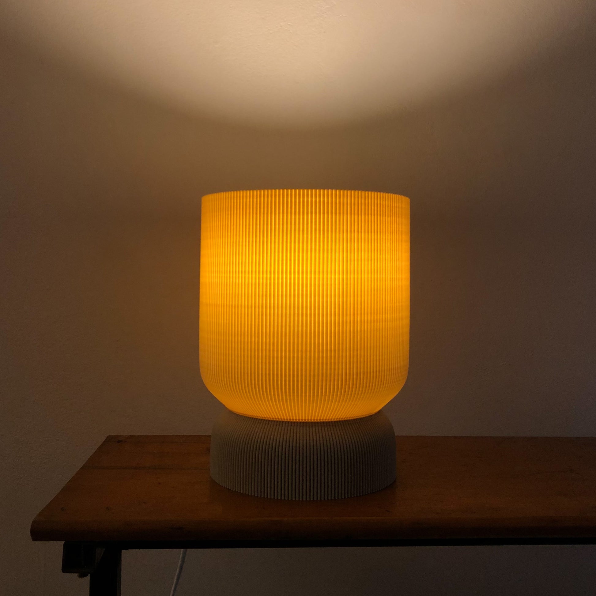a yellow lamp sitting on top of a wooden table