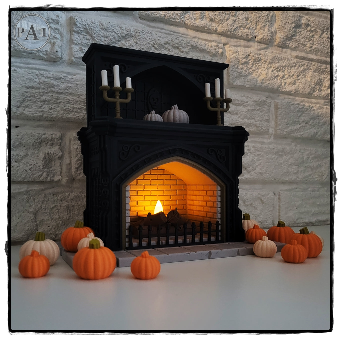 A miniature fireplace with a lit fire, surrounded by small orange pumpkins, creating a cozy autumnal scene.