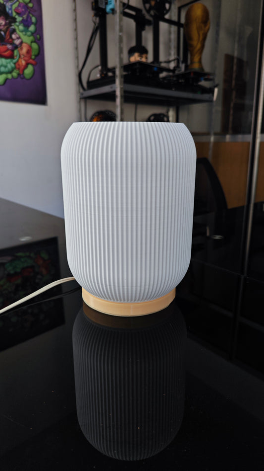 a white vase sitting on top of a black table