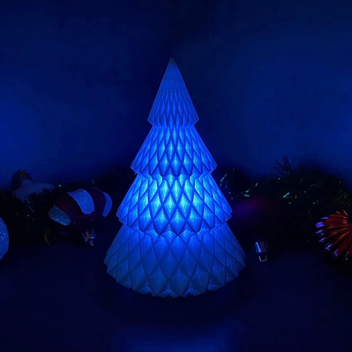 a blue lit christmas tree in a dark room