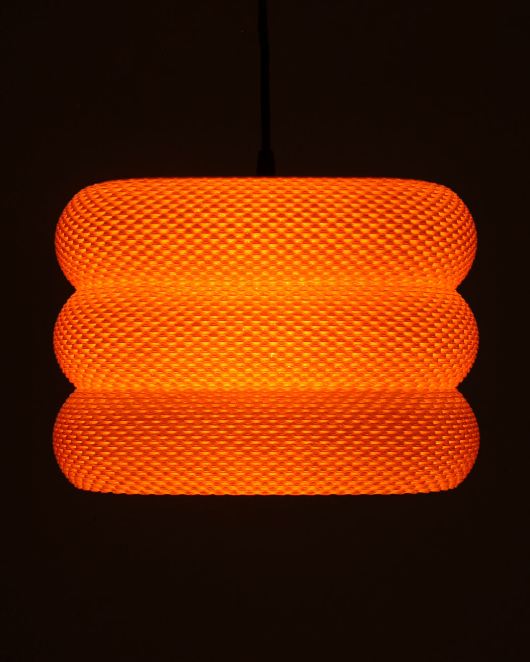 an orange light hanging from a ceiling in a dark room