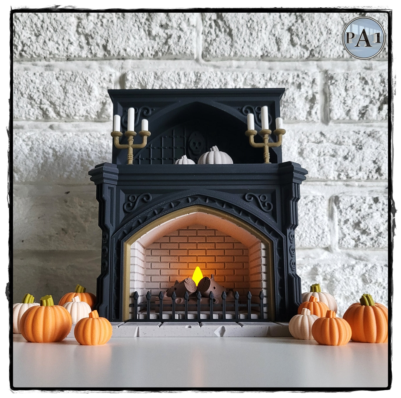 A miniature fireplace with a lit fire, surrounded by small orange pumpkins, creating a cozy autumn scene.