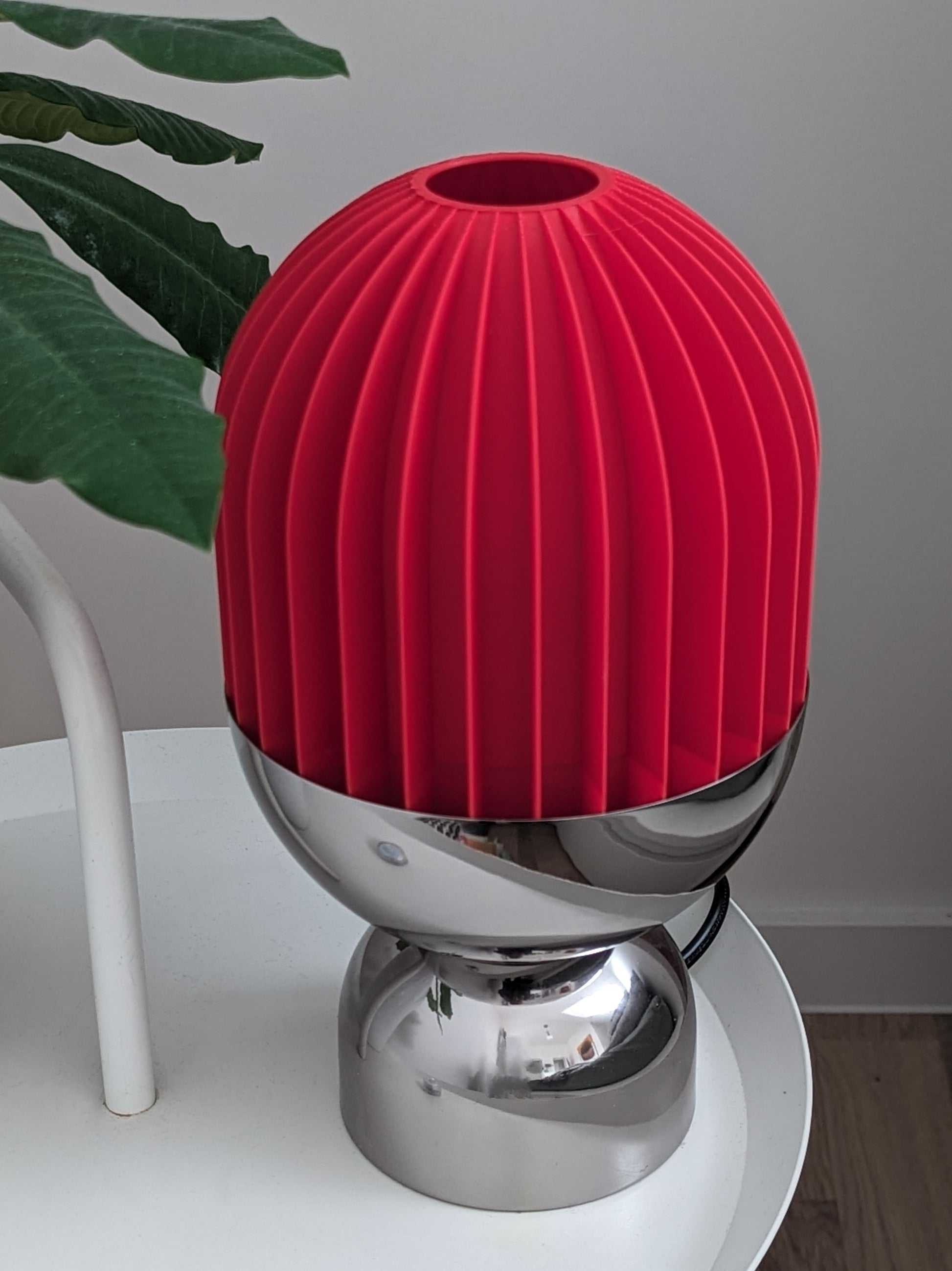 a red vase sitting on top of a white table