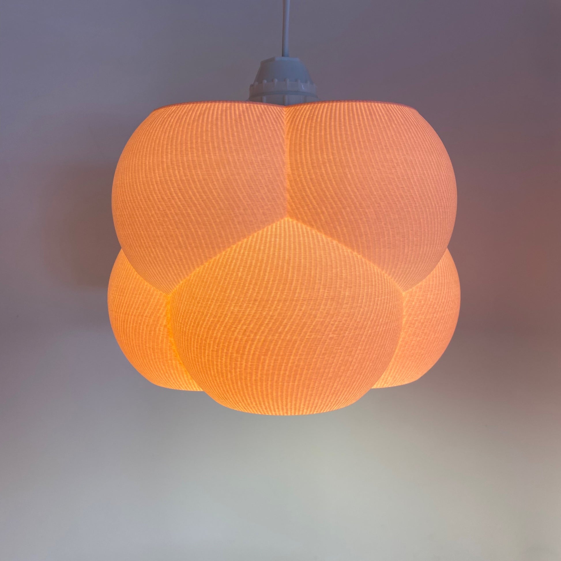 a large orange light hanging from a ceiling