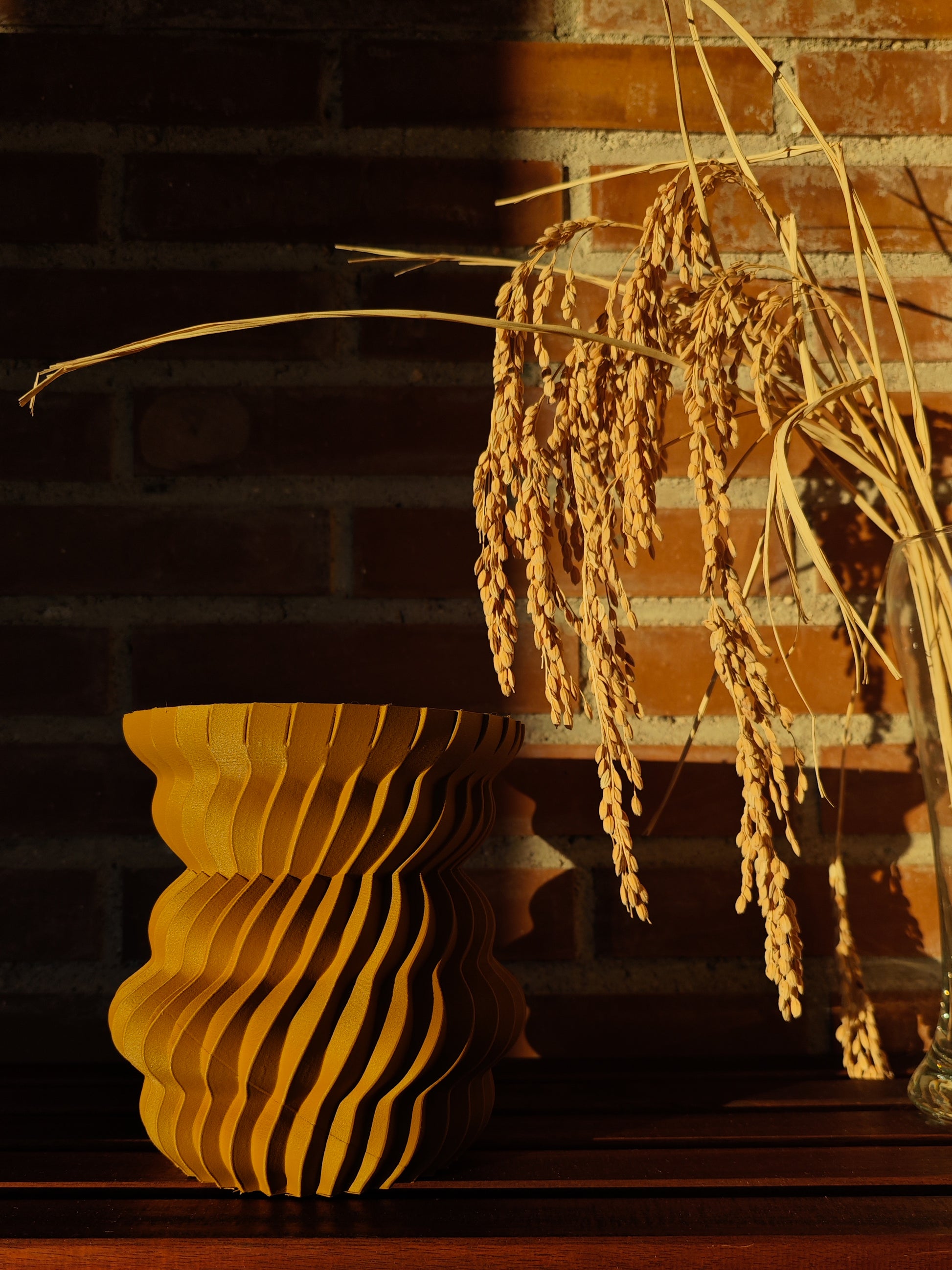 a yellow vase sitting on top of a wooden table