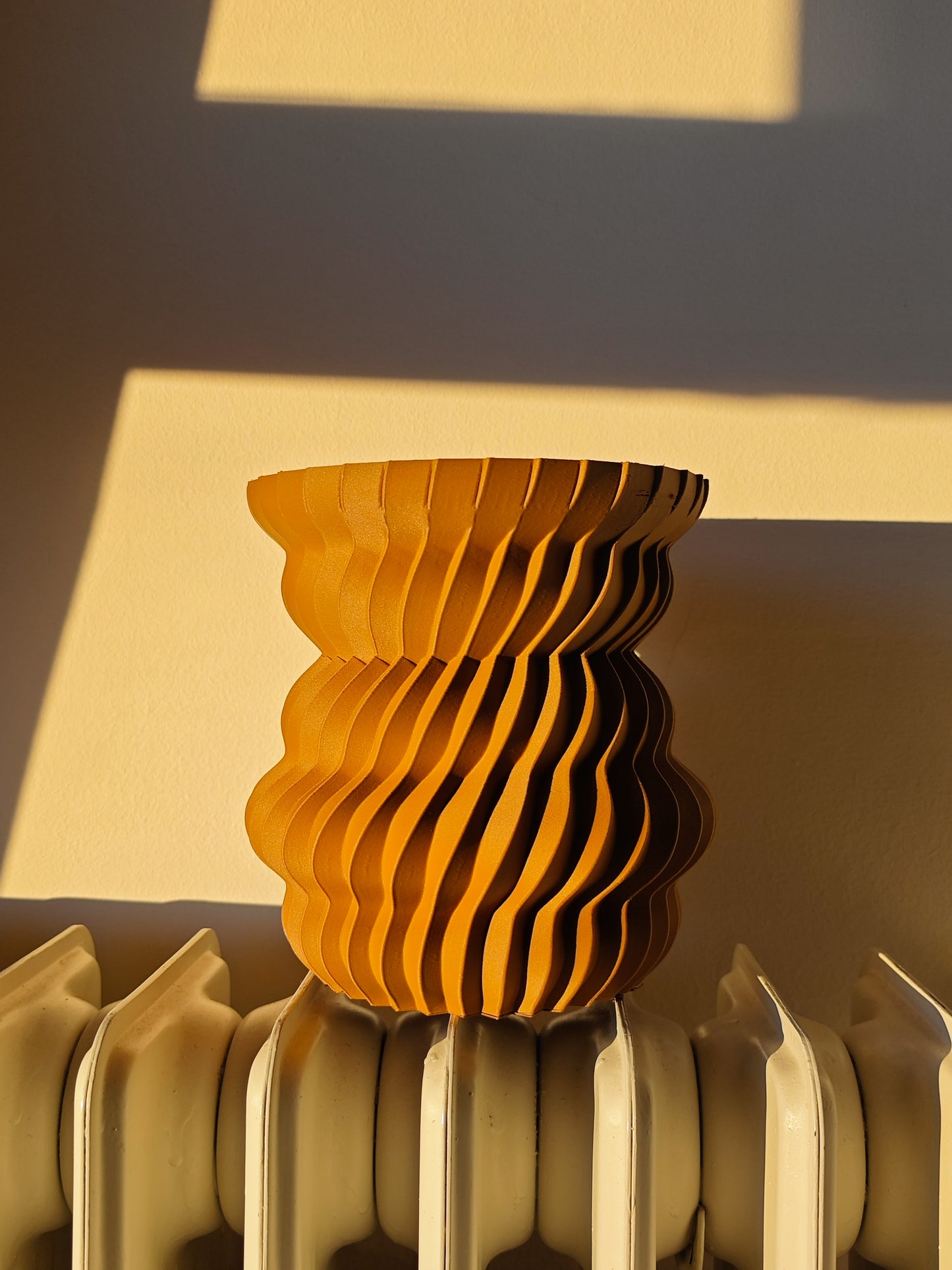 a yellow vase sitting on top of a radiator