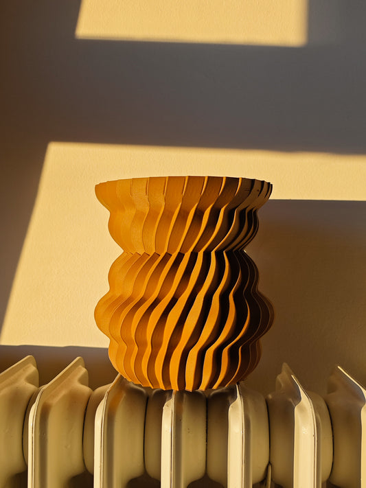 a yellow vase sitting on top of a radiator